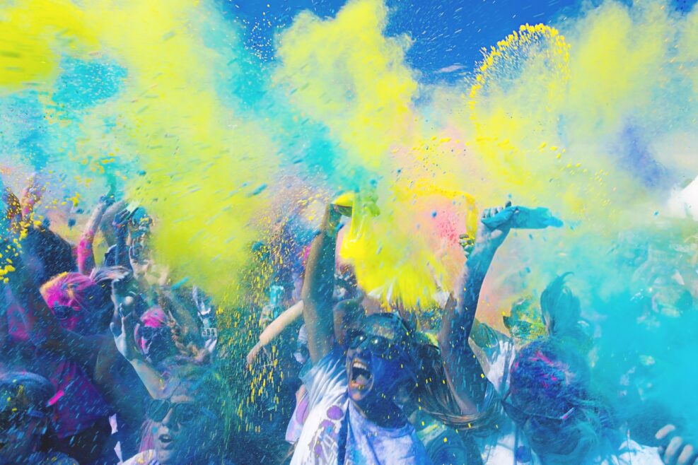 Yelling and screaming amidst colorful powder in the air