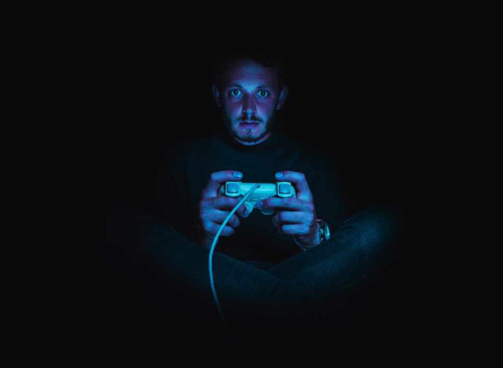 Man holding game controller in the dark