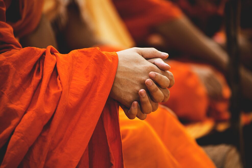 Orange gown and hands of buddhist