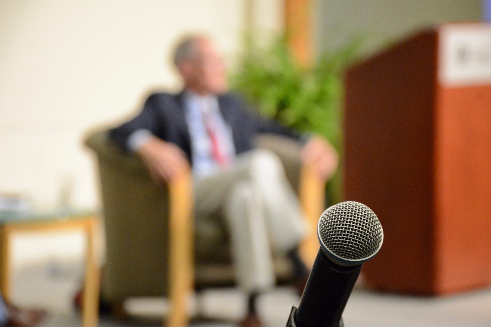 George Gilder with a microphone in the foreground