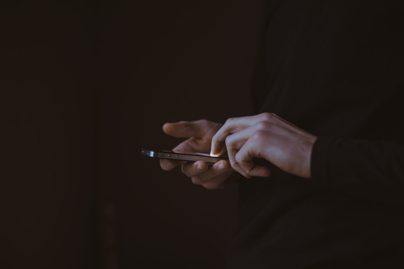 Hands in dark using smartphone