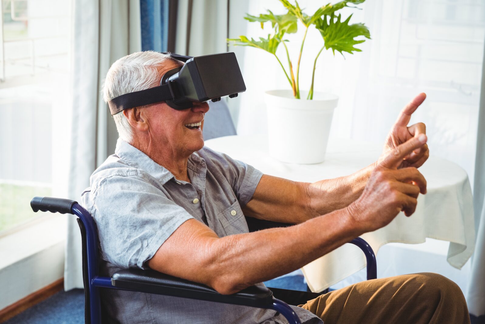 Senior man in a wheelchair using a virtual reality device
