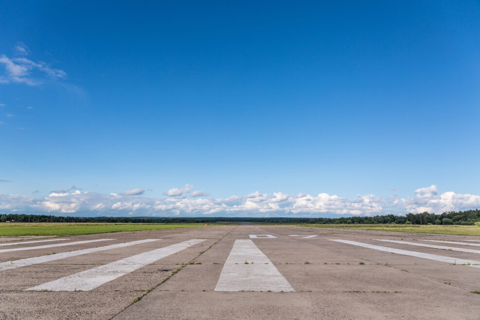The runway of a rural small airfield against a blue sky