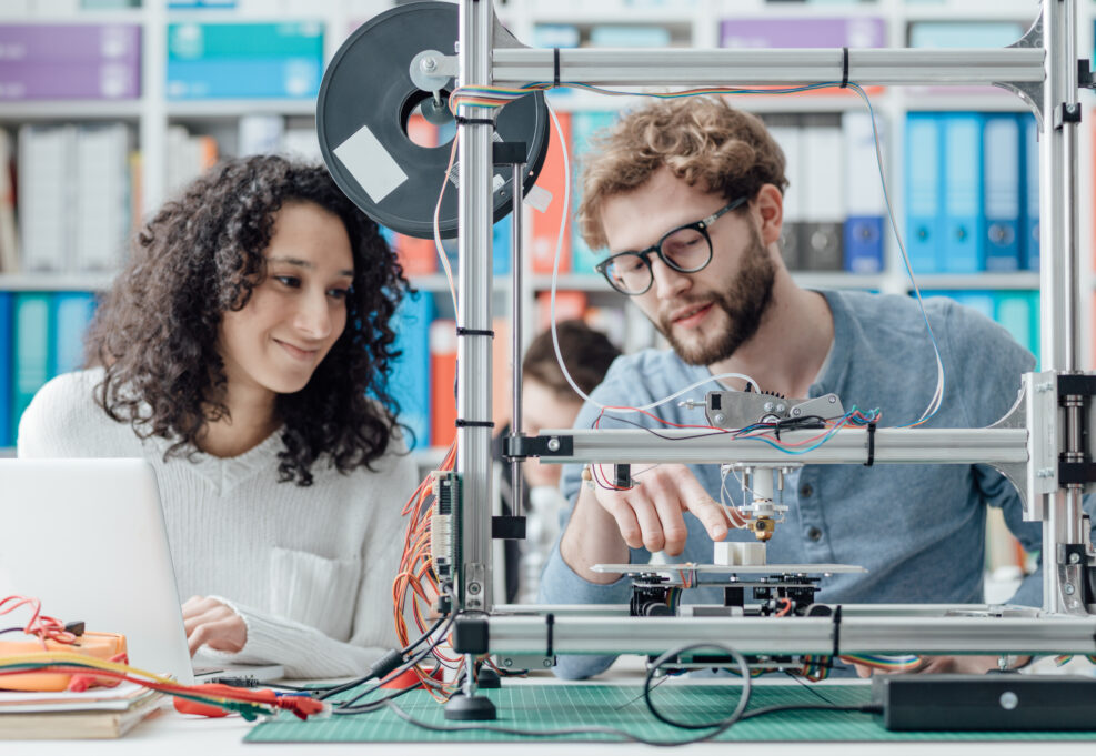 Engineering students using a 3D printer