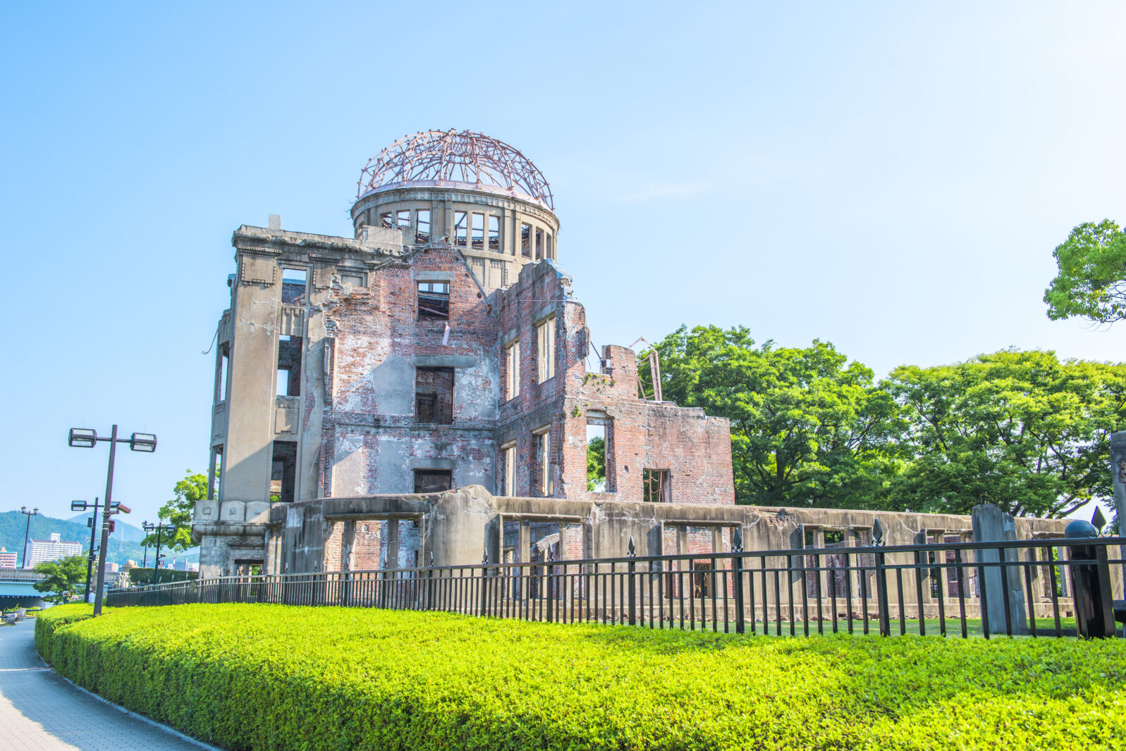 The Atomic Bomb Dome Panorama in Hiroshima and the surounding garden in autumn at sunset on the side of Motoyasu River in Japan, with the Peace Memorial Park