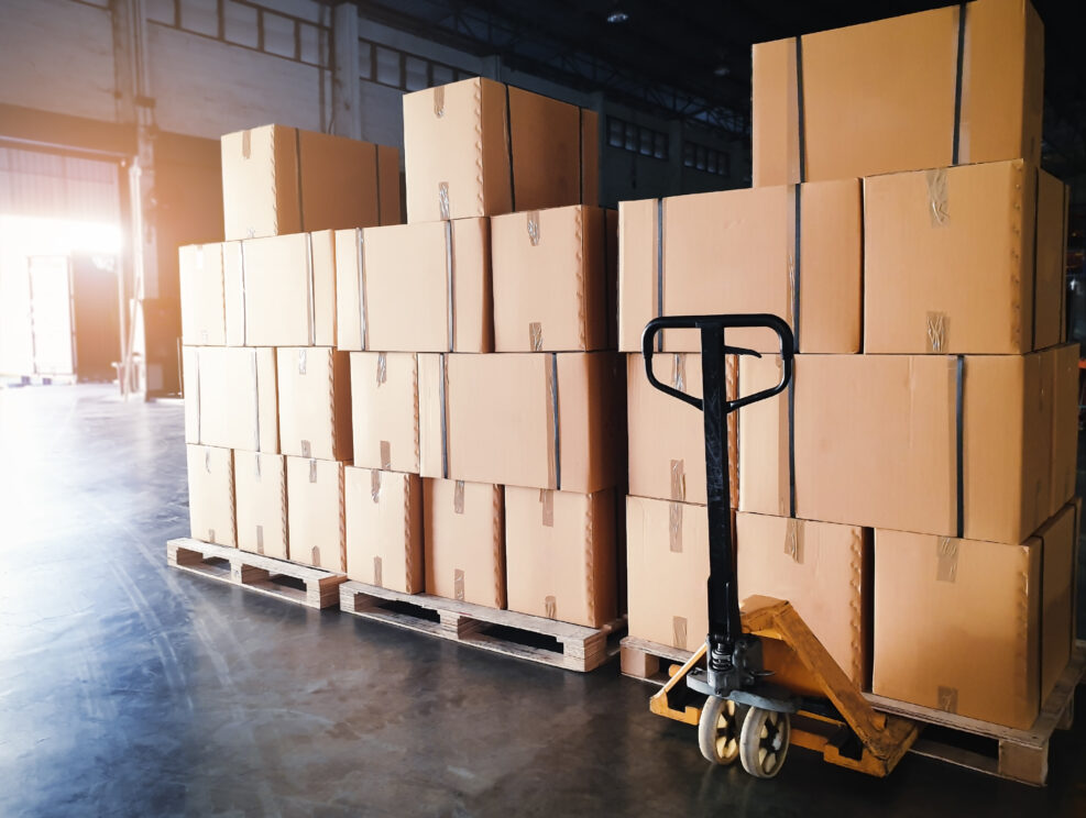 Interior of warehouse storage, Stack of shipment boxes on pallets and hand pallet truck, Warehouse industry delivery shipment goods, logistics and transportation.