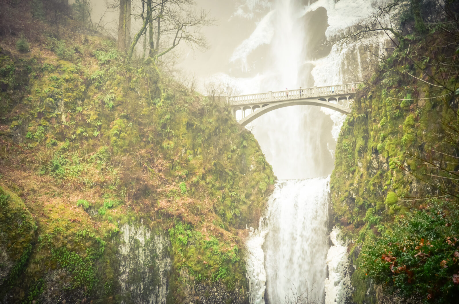 Vintage tone beautiful pedestrian stone bridge and knee-wobbling vantage point over the second tier 69-foot drop of Multnomah Falls lower in winter time. Natural and seasonal waterfall background
