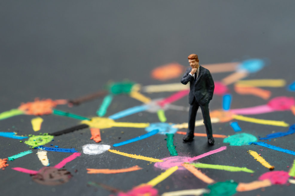 Anti social man, business connection or social network concept, miniature people businessman standing on colorful pastel chalk line link and connect between multiple dot or tiers on blackboard