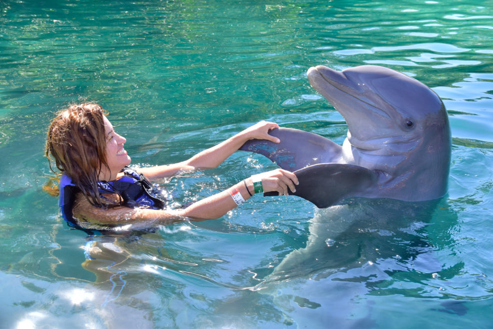 Young girl playing with dolphin in Xel-ha park, Rivera Maya, Mexico