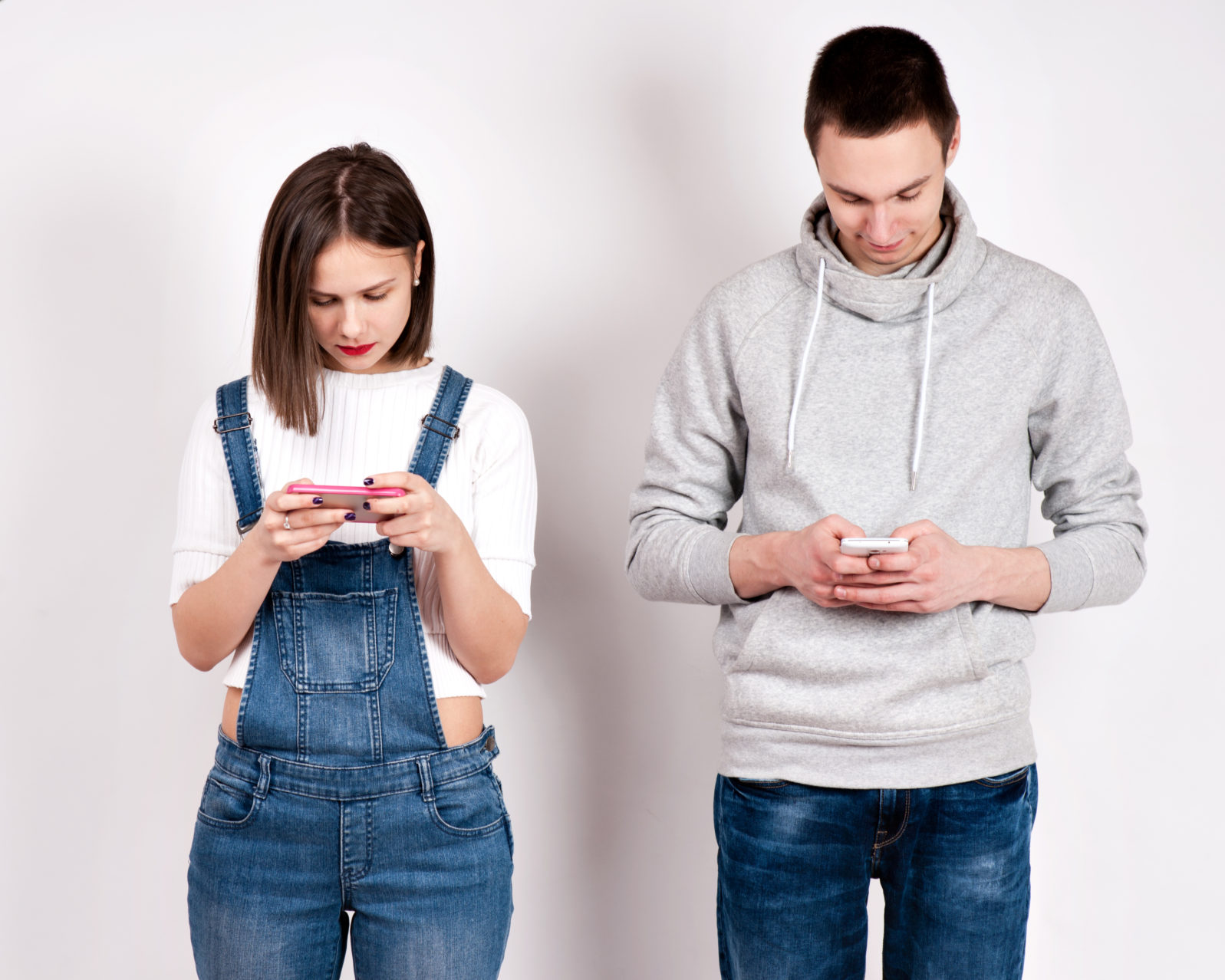 Divided young couple busy with their smartphones each