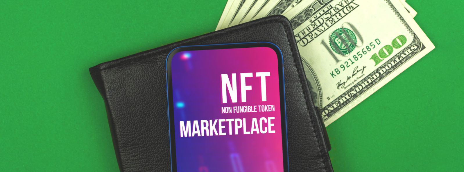 Cryptographic NFT non fungible token marketplace, cryptoart and blockchain logo on the screen of modern mobile phone, black wallet and dollar money on the office table, banner top view photo