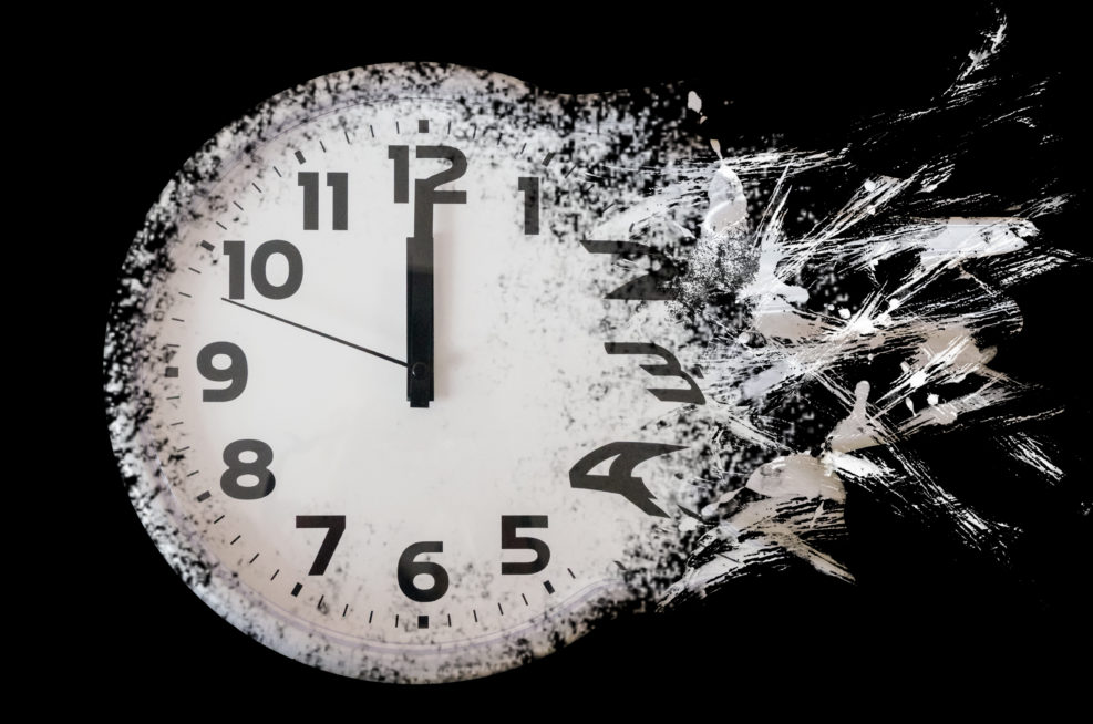 Time is running out concept shows clock that is dissolving away into little particles. Black and white wall clock