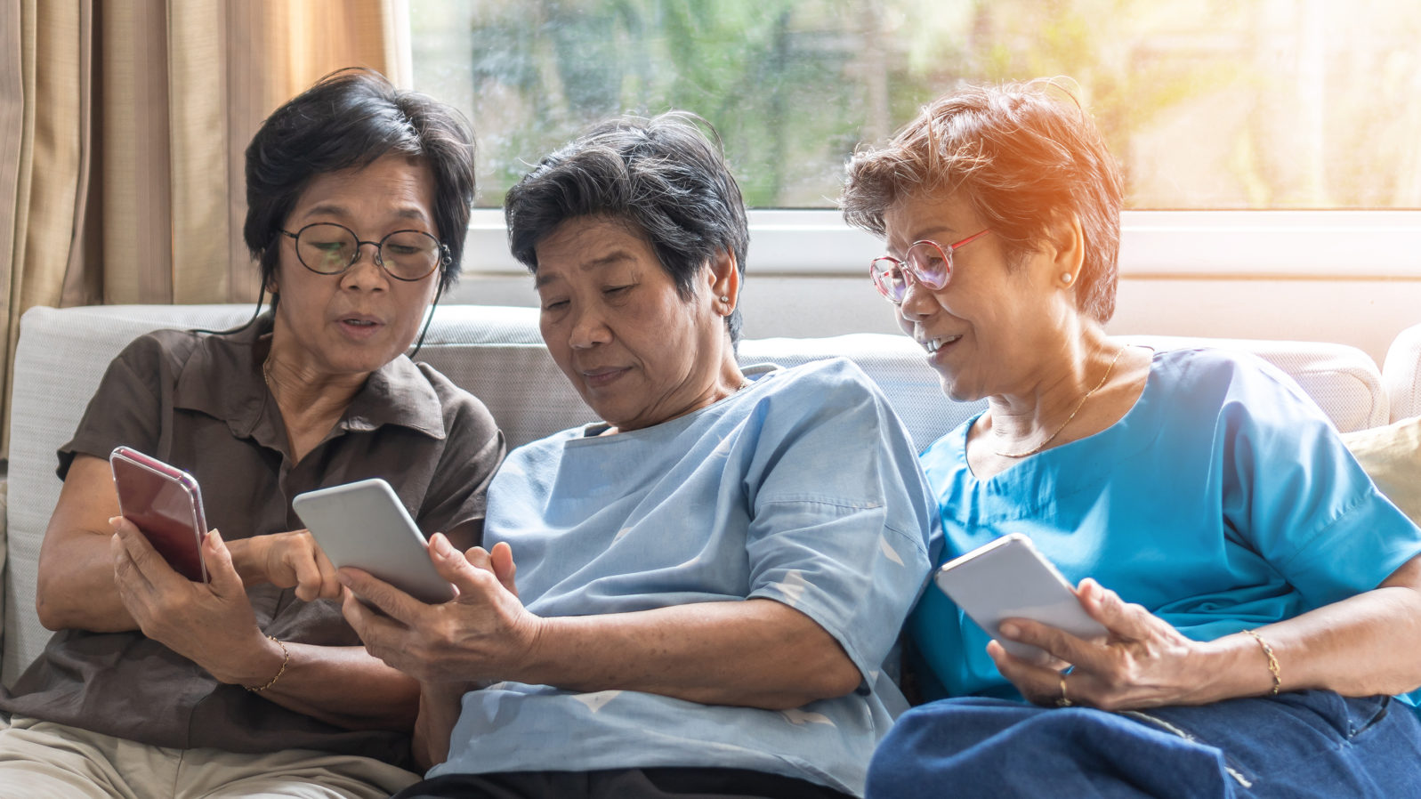 Ageing society concept with Asian elderly senior adult women sisters using mobile digital smart phone application technology for social media network among friends community via internet communication