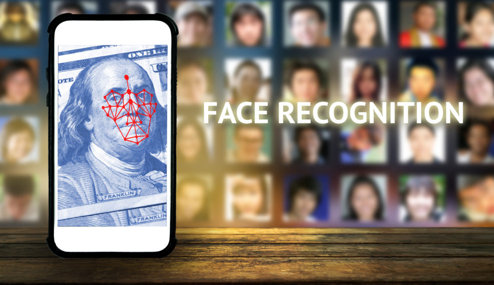 Machine learning systems and accurate facial recognition concept , smart phone with blue screen and blur human faces background