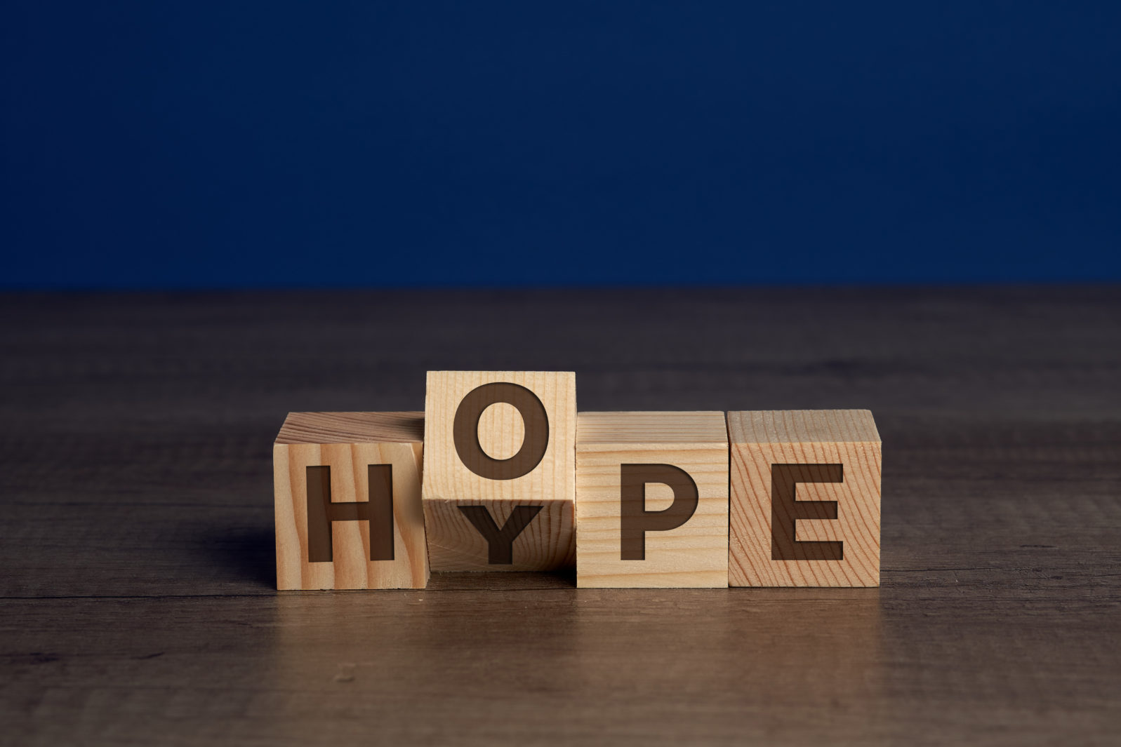 Words HYPE and HOPE written on blocks of wood. The word HOPE goes over the word HYPE.