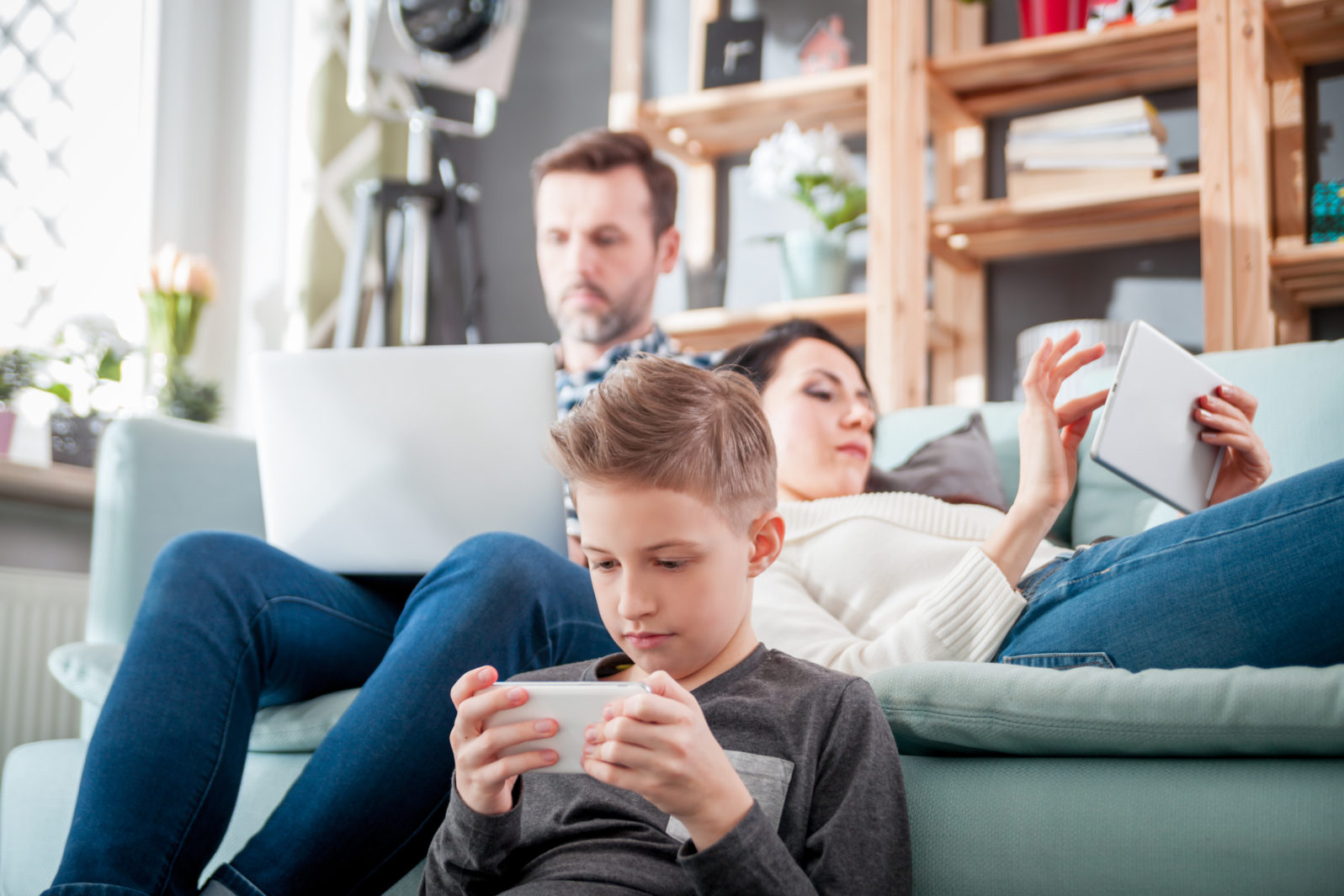 Family with laptop, tablet and smartphone, everyone using digital devices