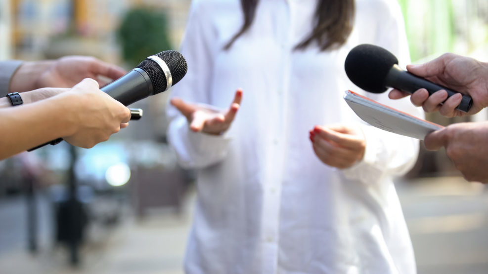 Female politician talking on media press conference, public relations, event