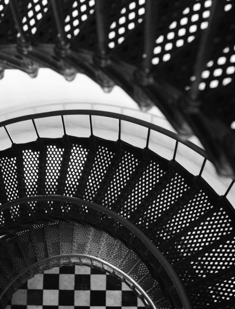 black metal spiral staircase in grayscale photography