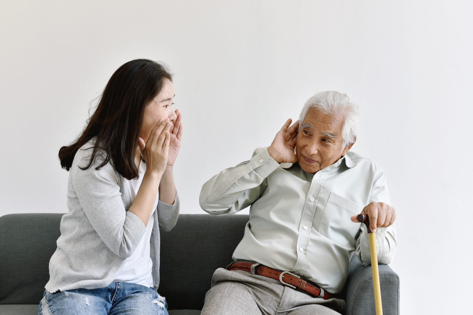 Hearing loss problem, Asian old man with hand on ear gesture trying to listen shouting woman, Aging senior decline in hearing ability, Elderly health problems concept.