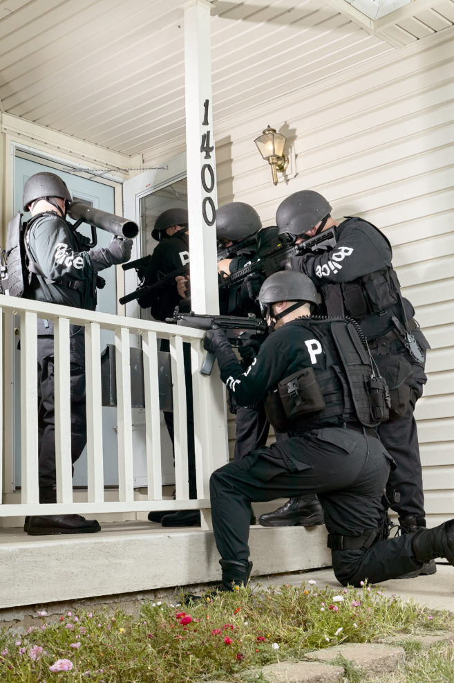 Police tactical team gathered round a house