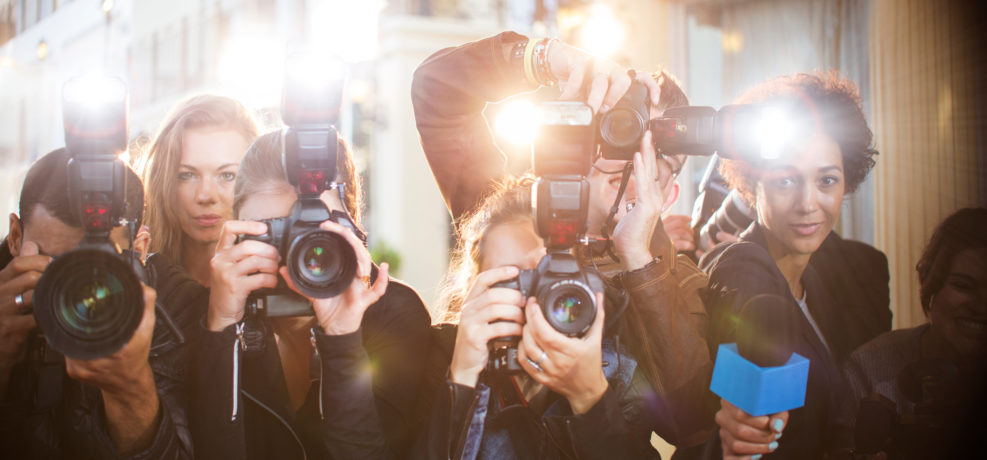 Portrait of paparazzi in a row with cameras and microphone