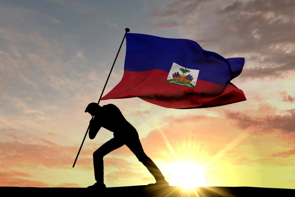 Haiti flag being pushed into the ground by a male silhouette. 3D Rendering