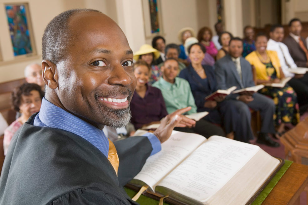 Preacher at altar with Bible preaching to Congregation portrait close up