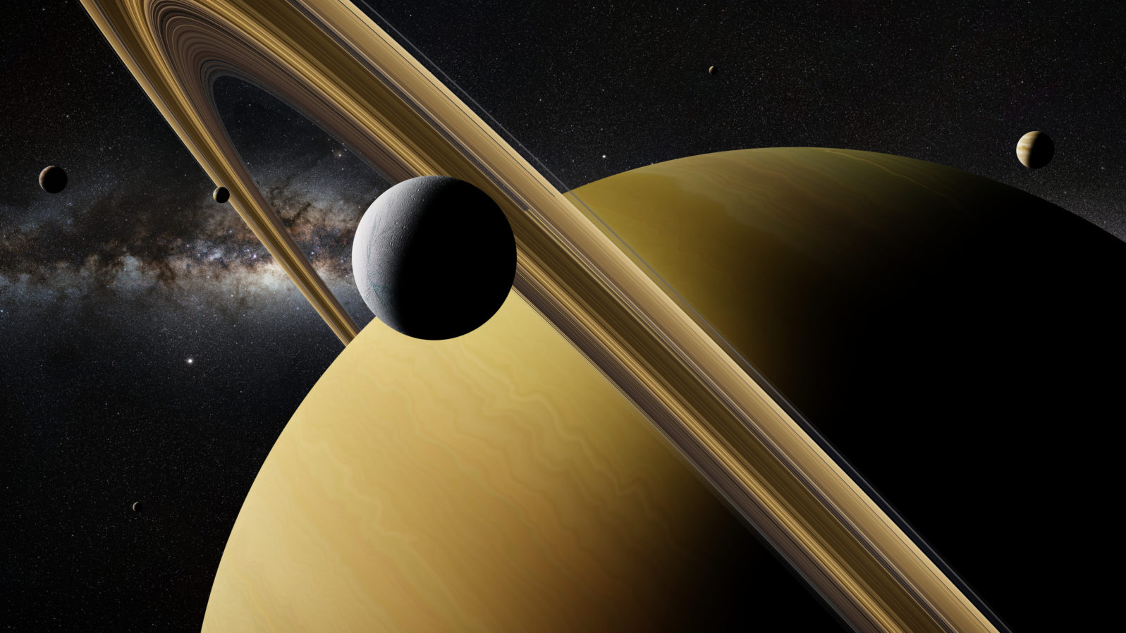 Saturn moon Enceladus in front of planet Saturn, rings, other moons and the Milky Way galaxy
