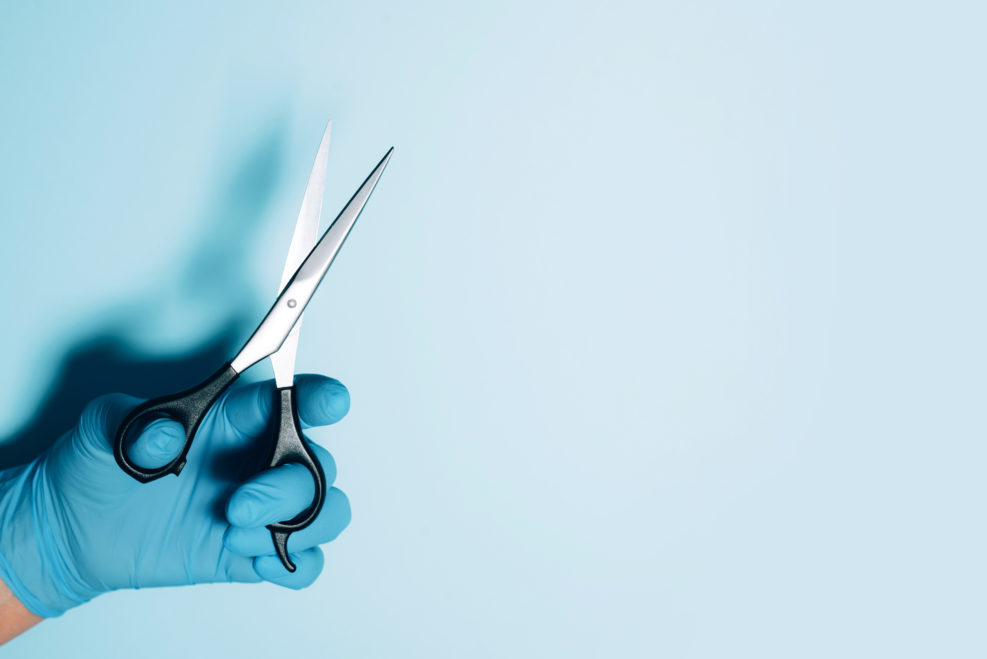 Hairdresser's hands with scissors. New normal concept. Copy space. Stay safe. Health protection equipment during quarantine Coronavirus pandemic. Covid 19