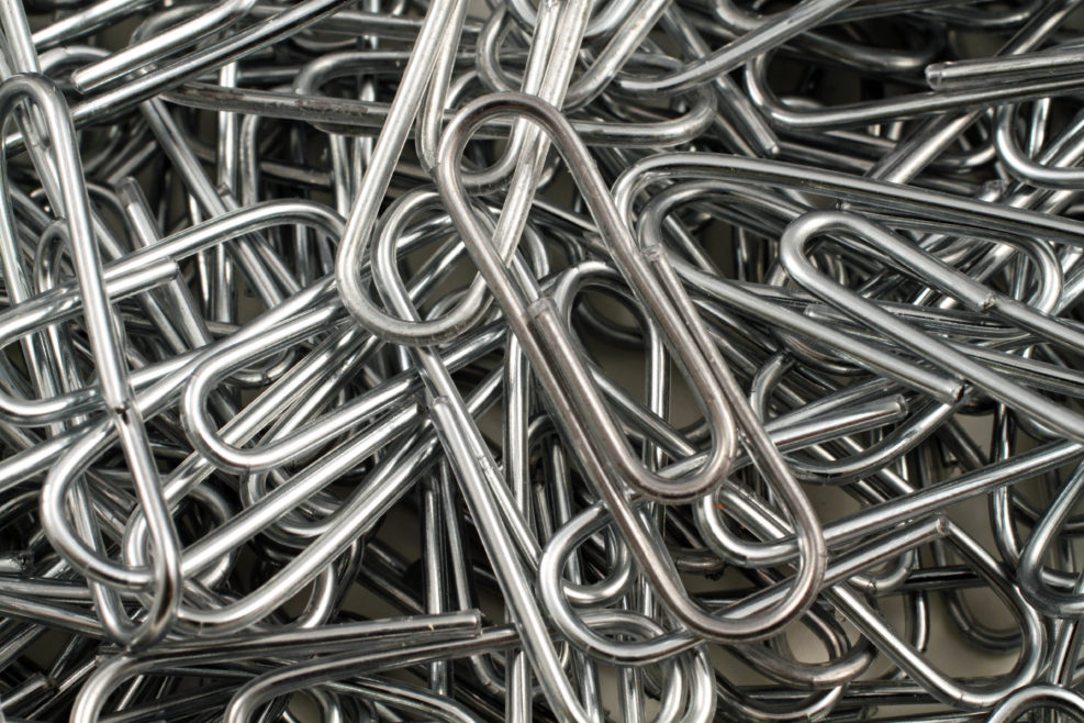 An extreme close up image of metal paper clips