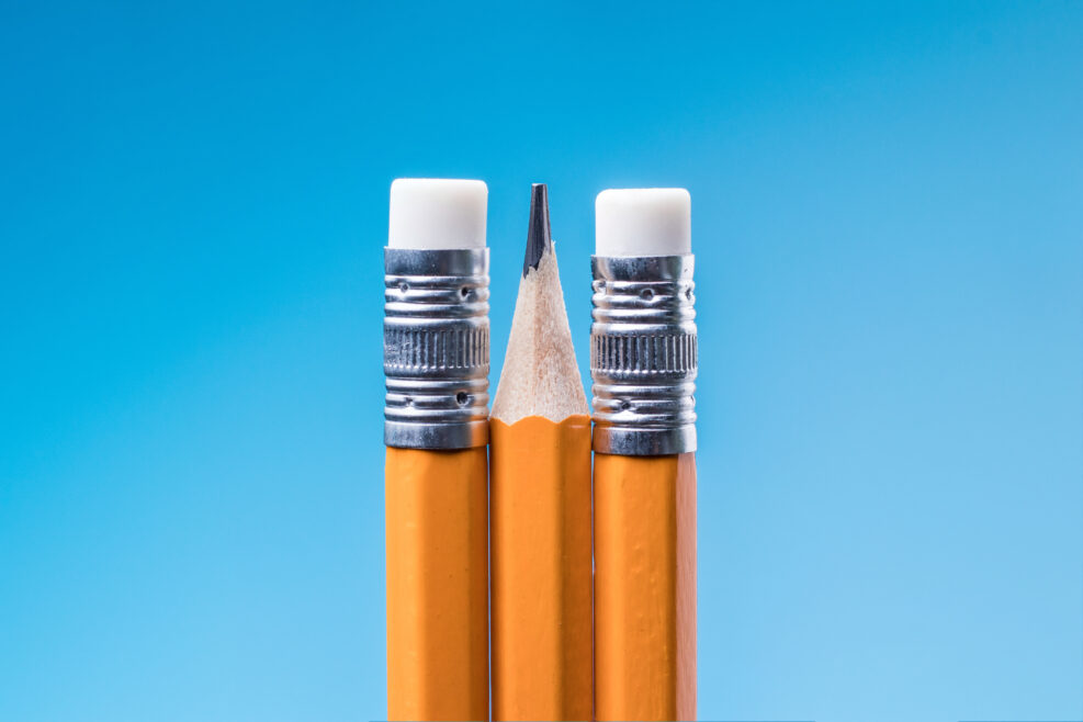 A sharp pencil between two erasers on a blue background.Unfree creativity and censorship, concept