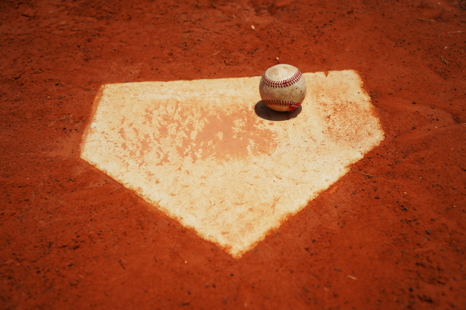 Baseball on home plate on baseball field