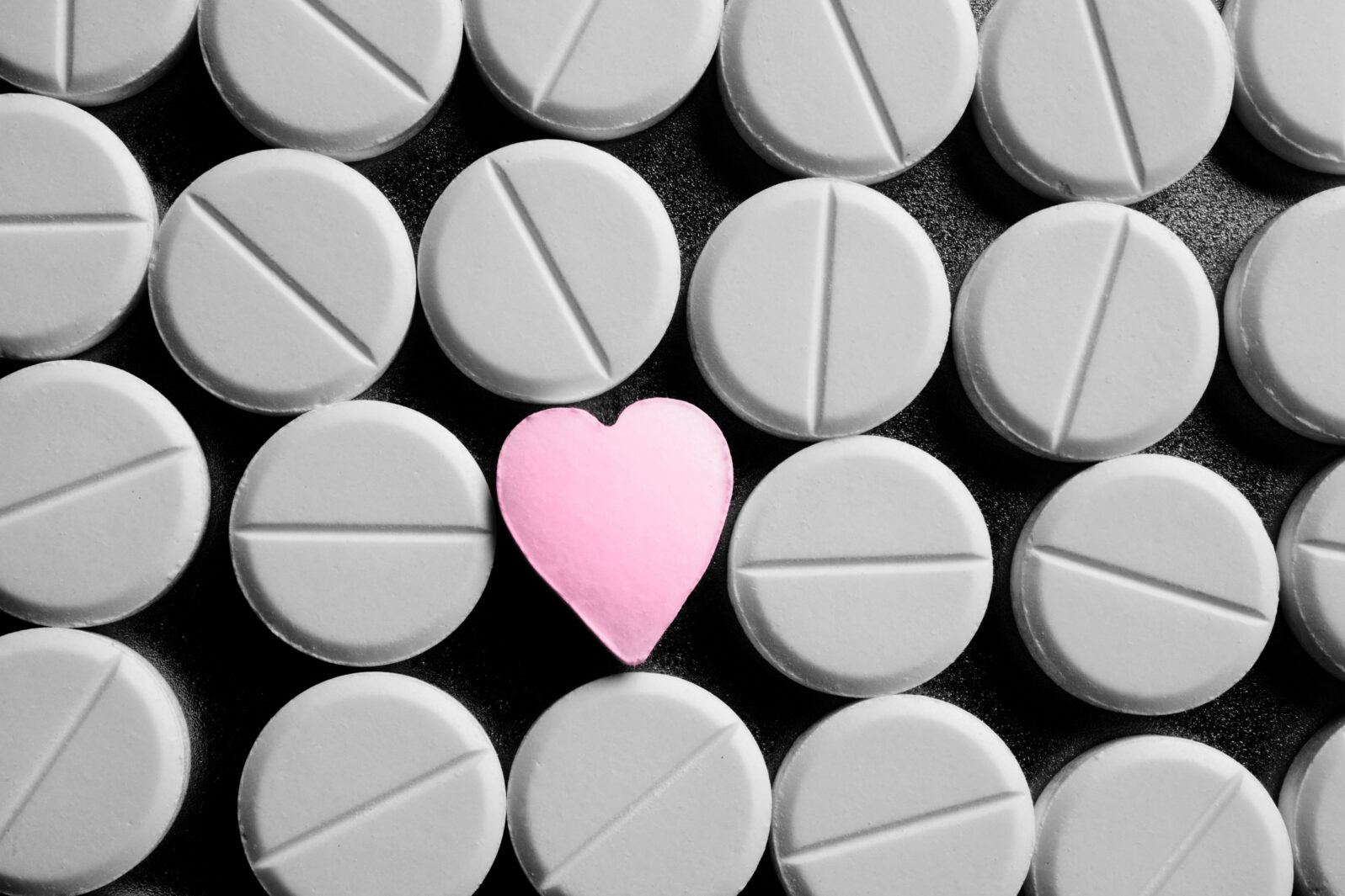 Heart shaped pill between rows of standard pills