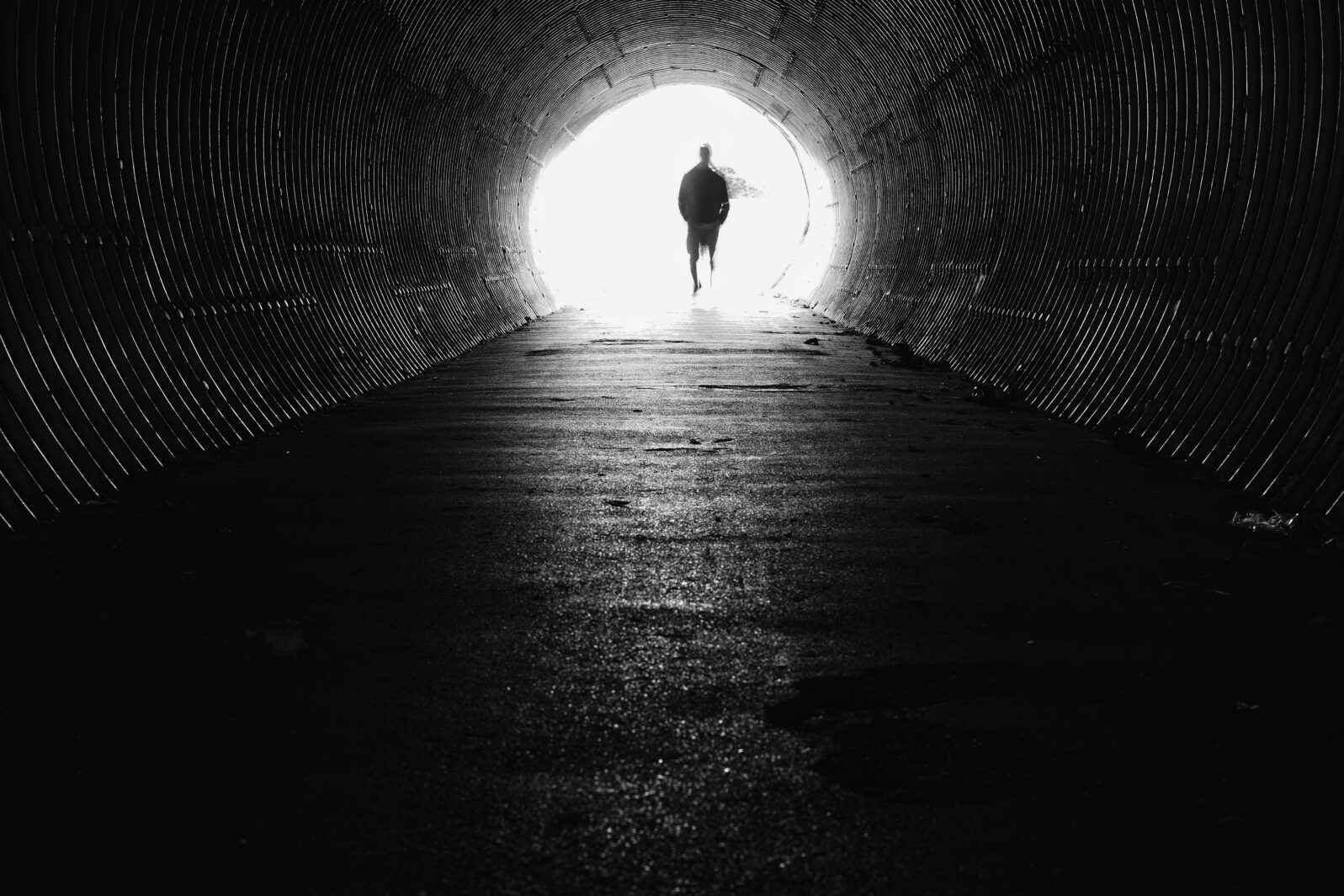 light at the end of the tunnel with silhouette of man