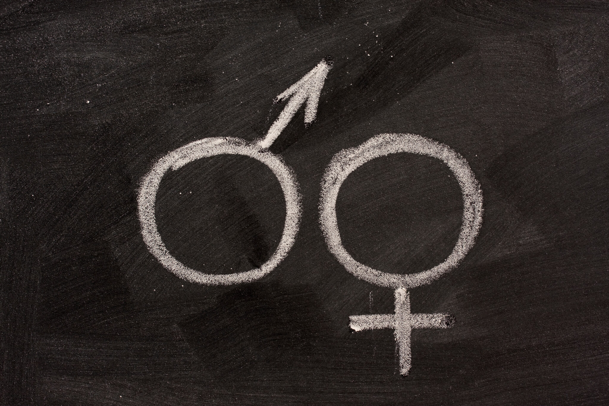 male and female gender symbols on blackboard