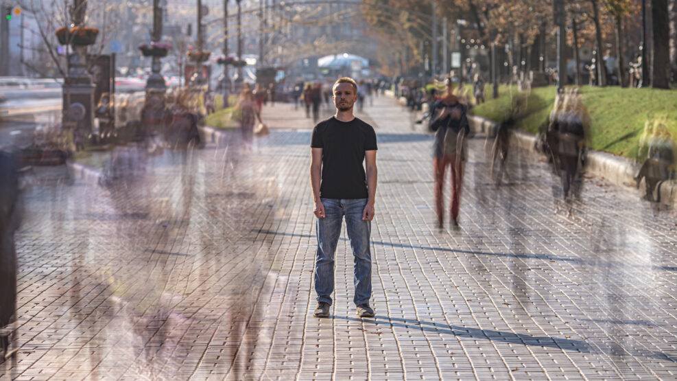 The young man stands on the crowdy street