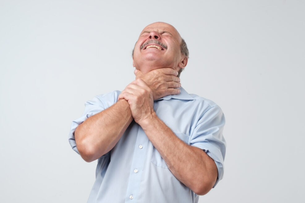 Alien hand syndrome. Mature man trying to control his hand.