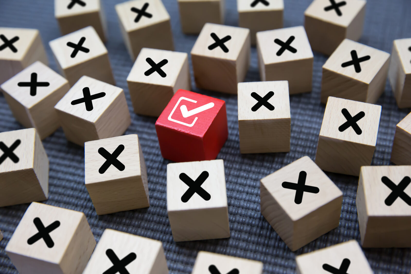 Close-up check mark on cube wooden toy block stack with cross symbol for true or false changing mindset or way of adapting to change leader and transform quiz answer and poll concept.