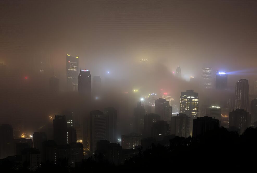 _ - . A city shrouded in fog, lights from buildings creating a m