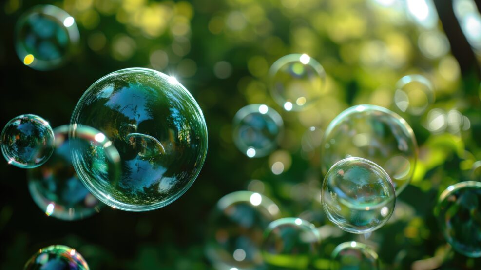 Translucent soap bubbles floating with natural green backdrop