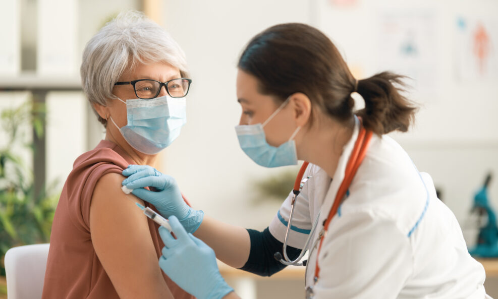 Doctor vaccinating a senior woman