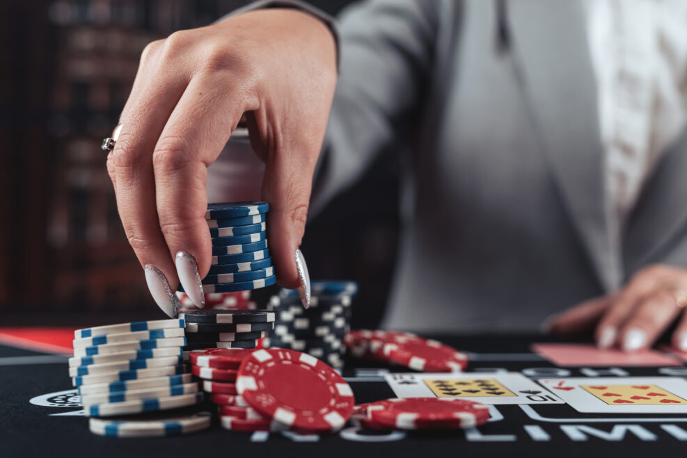 female player plays poker and takes chips to raise the bet