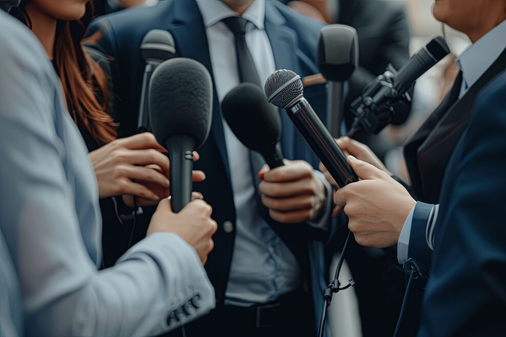 Media Interview - journalists with microphones interviewing formal dressed politician