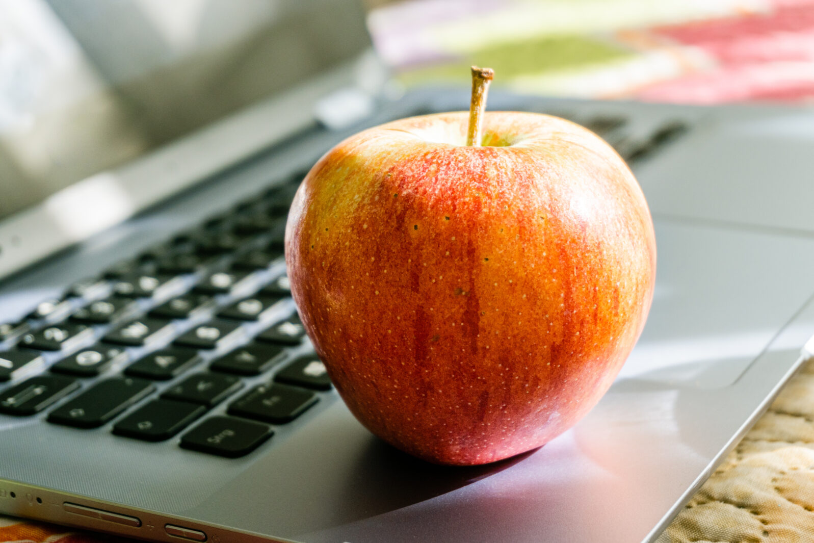 Side view close-up, apple on laptop, healthy snack based on fruit.