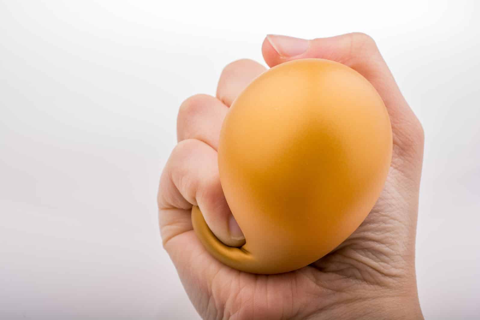 Squeezing yellow balloon with hand