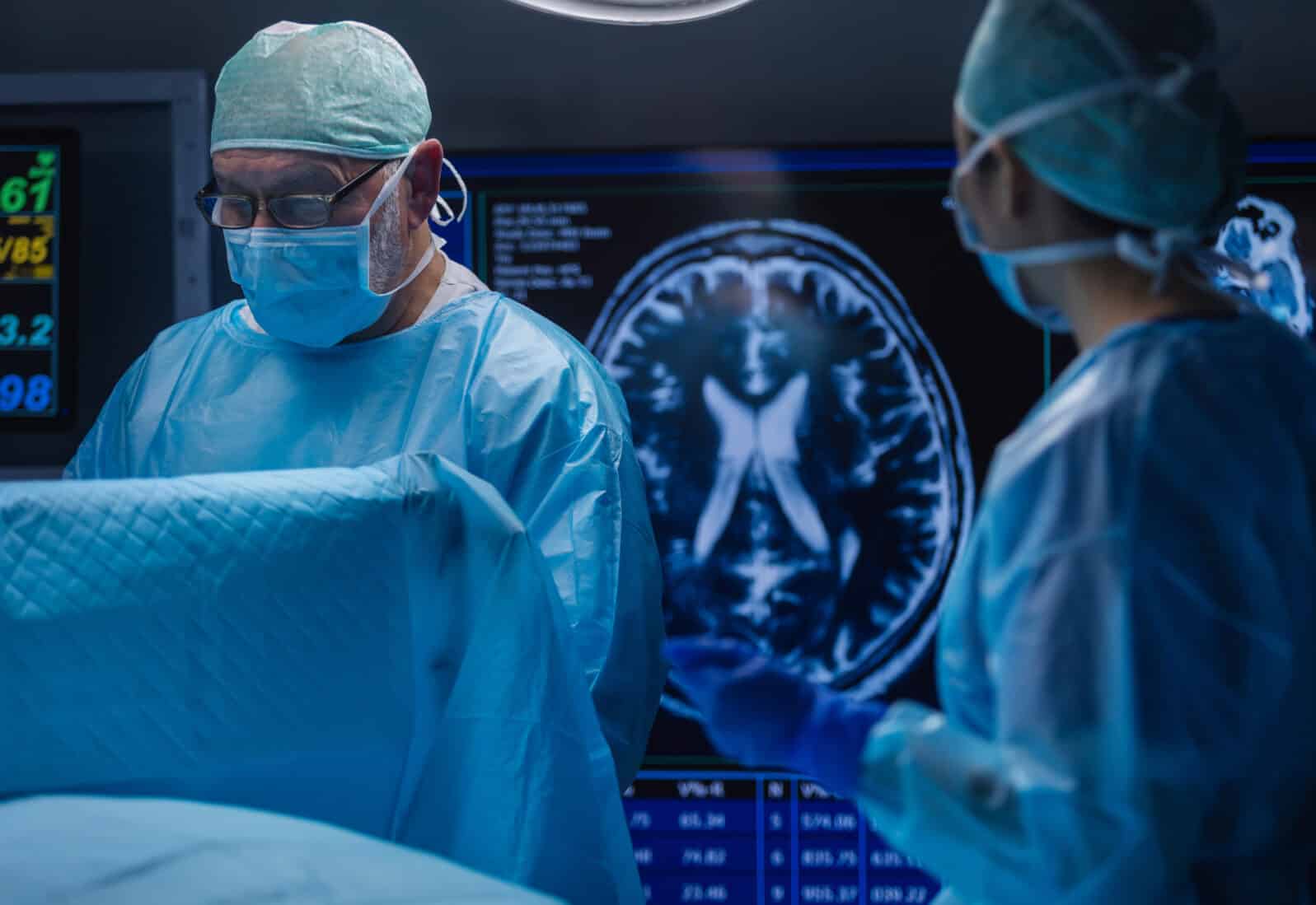 Multiracial team of professional medical surgeons performs the surgical operation in a modern hospital. Doctors are working to save the patient. Medicine, health and neurosurgery.