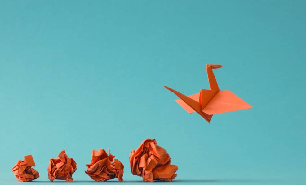 New ideas or transformation concept with crumpled paper balls and a crane, teamwork, creativity, business concept