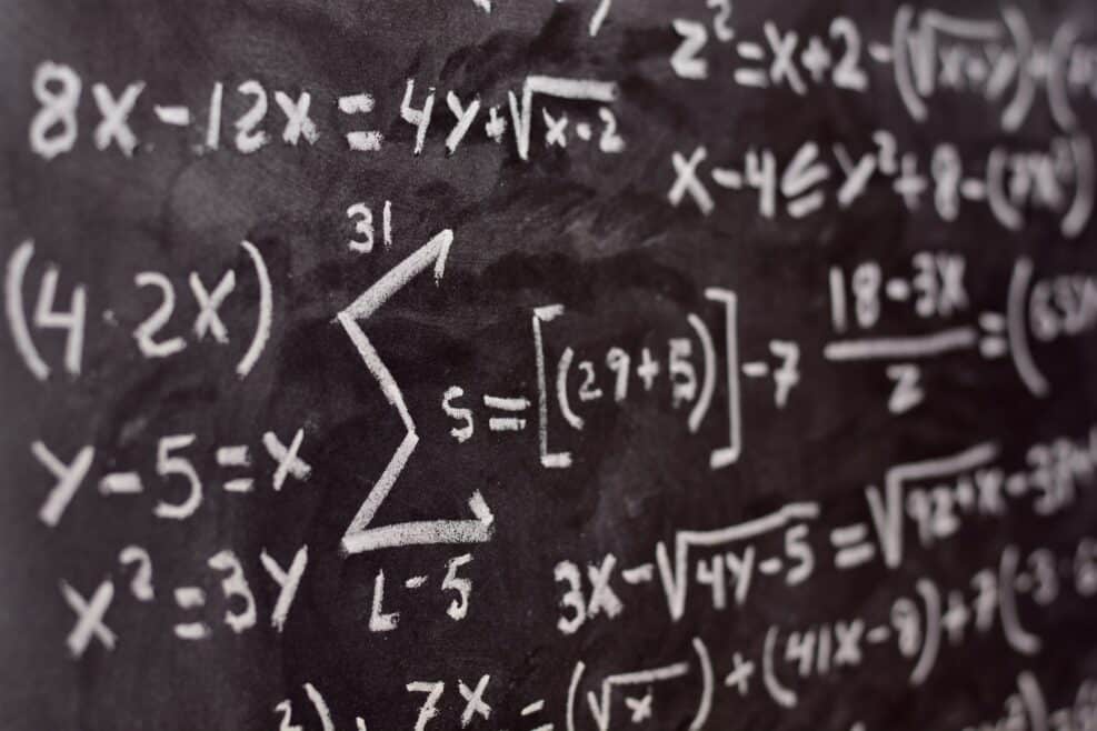 Operaciones matemáticas escritas a mano con una tiza en la pizarra