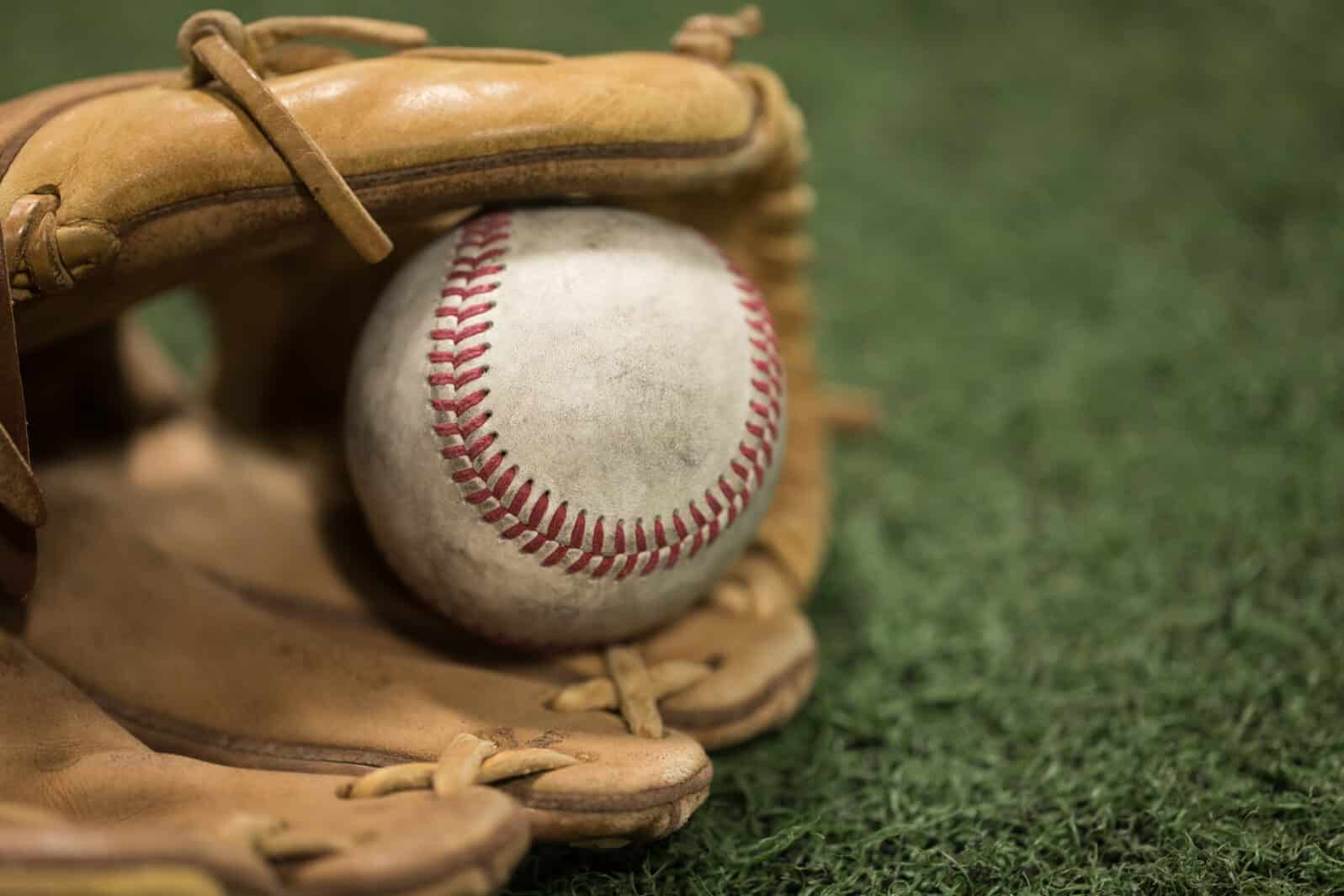 Closeup of Baseball Glove and Baseball on turf