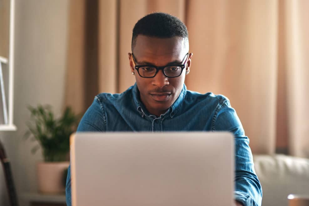 Freelance blogger typing on laptop, thinking of blog post or planning off story vision while working from home living room. Serious, ambitious or inspired writer or entrepreneur working on technology